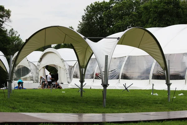 Festival white big tents and arbor are set for the festive reception in the park on holiday