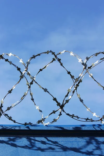 Barbed wire. Barbed wire on fence with blue sky to feel worrying.