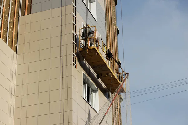 Sarı asma beşik işçi bir yeni inşa edilen yüksek katlı bina yalıtımı için çevre kurulları bağlar