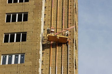Sarı asma beşik işçi bir yeni inşa edilen yüksek katlı bina yalıtımı için çevre kurulları bağlar