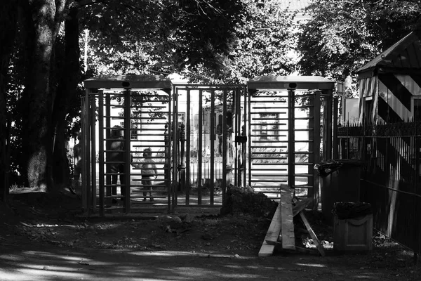 Περιστροφική πύλη πλήρης-ύψους στροφέα ηλεκτρομηχανολογικών είναι εγκατεστημένη στην είσοδο στο πάρκο της Gatchina για τον έλεγχο και να περιορίσετε το ταξίδι των ποδηλάτων. Μαύρο και άσπρο φωτογραφία — Φωτογραφία Αρχείου