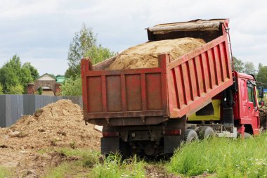 İnşaat kamyonu kaldırır nerede su ile boru hattı döşeme kum onarım sitesinde. Taksi üzerinde sarı boş reklam tente