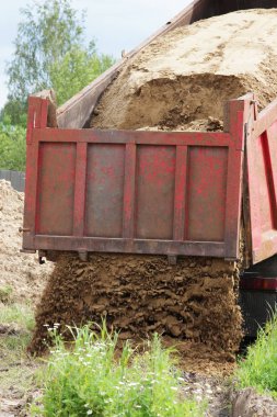 İnşaat kamyonu kaldırır nerede su ile boru hattı döşeme kum onarım sitesinde. Taksi üzerinde sarı boş reklam tente