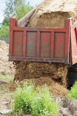 İnşaat kamyonu kaldırır nerede su ile boru hattı döşeme kum onarım sitesinde. Taksi üzerinde sarı boş reklam tente