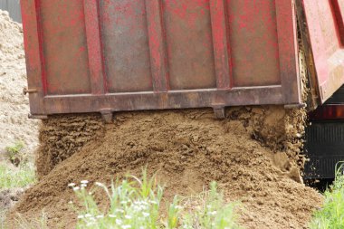 İnşaat kamyonu kaldırır nerede su ile boru hattı döşeme kum onarım sitesinde. Taksi üzerinde sarı boş reklam tente