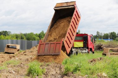 İnşaat kamyonu kaldırır nerede su ile boru hattı döşeme kum onarım sitesinde. Taksi üzerinde sarı boş reklam tente