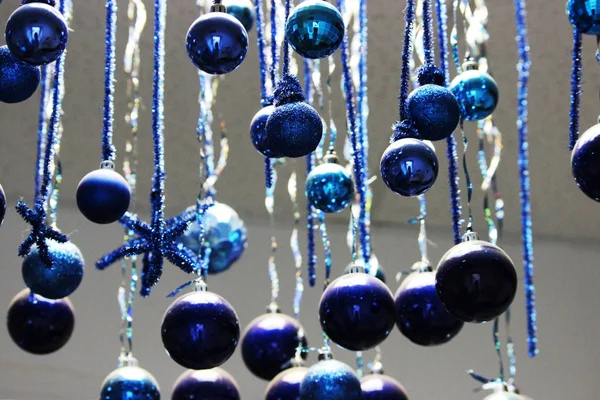 De nombreux jouets d'arbre de Noël bleus sont accrochés au plafond. Décoration de Noël . — Photo