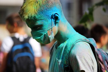 Genç adam Gatchina, Rusya Federasyonu festival Holi Festival kuru çok renkli boya ile boyanmış.