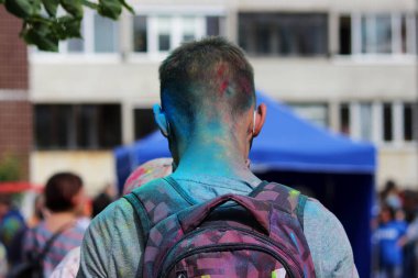 Genç adam Gatchina, Rusya Federasyonu festival Holi Festival kuru çok renkli boya ile boyanmış.