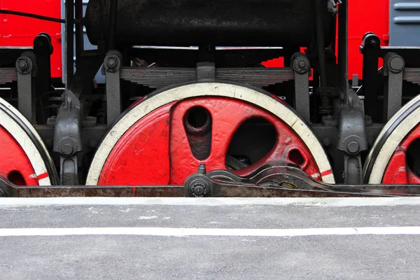 Potenti ruote di vecchie locomotive poggiano sui binari ferroviari il giorno del ferroviere . — Foto Stock