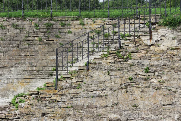 Denize açılmaya elverişli gemilerden geçmek için kilidi olan tarihi bir kanalda suya inen raylı eski bir taş merdiven. Yıkılmış duvarların dokusu.