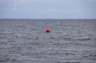 Bulutlu bir günde denizde turuncu bir şamandıra. Gemiler için denize elverişli yol