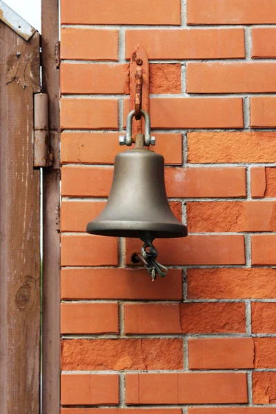 A large bell next to the door, replacing the doorbell. the bell Welcome. Ring the bell