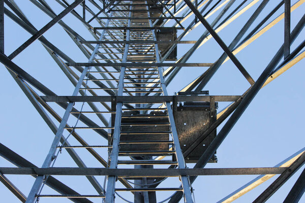 Large tower of metal structures against the blue sky. Metal construction