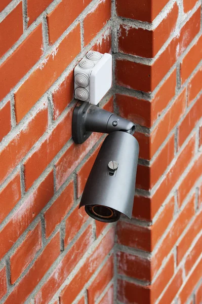 A video camera on a red brick wall protects the territory from the invasion of strangers. — Stock Photo, Image