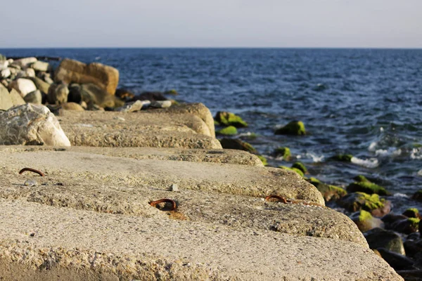Kıyıyı erozyondan korumak için büyük beton dikdörtgen bloklar denizde yatıyor. Demiryolu raylarının kapatılması.