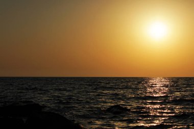 Karadeniz 'de gün batımı zamanı. Turuncu renk. Kıyı taşları