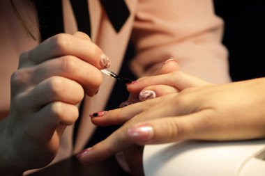 Manikür eğitim kursları öğrencisi gomalak uygulamadan önce istemcinin el hazırlar. koruyucu kaplama şeffaf gomalak kaplama çivi üzerinde uygulama