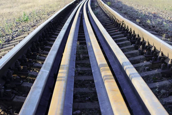 Több sínek feküdjön a között a fő sínek a vasúti talpfa. csavarok, hogy biztosítsa a sínek, hogy a irányától függően vasúti talpfa — Stock Fotó