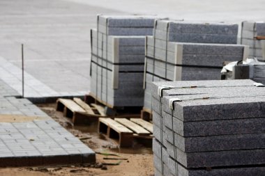 İnşaat için birçok kaldırım taşları inşaat alanındaki paletler üzerine döşenmiş levhalar şehir meydanında çalışır.