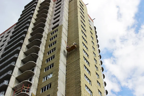 Arbeiter in gelber Front schwebte an einem neu errichteten Hochhaus — Stockfoto