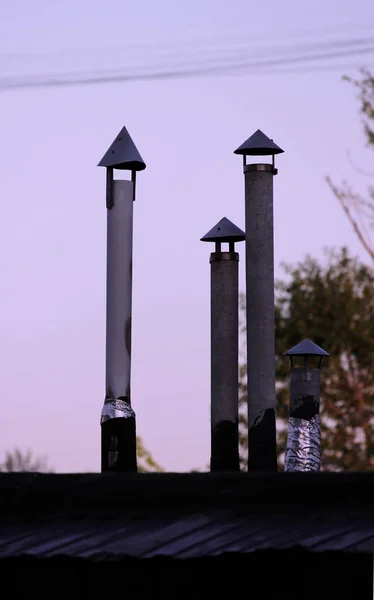 Vier schoorsteen pijp van metaal op het dak van het huis. — Stockfoto