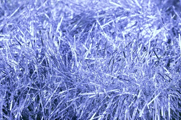 bir Noel şenlikağacı dekorasyon için altın bir arka plan üzerinde gümüş mavi tinsel.