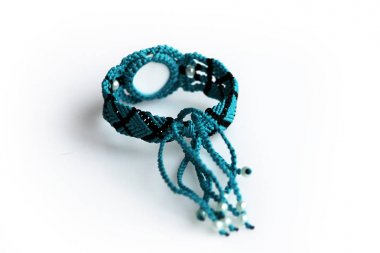 El mumlu iplik ve ejder gözü beyaz bir arka plan üzerinde makrome tekniği için turkuaz bilezik.