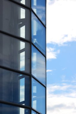 Büyük mavi cam pencere eşiği içinde şehir alışveriş merkezi ve gökyüzü.