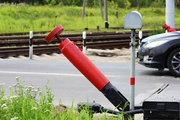 Railway crossing, anti-RAM devices. Red crossing fence device that automatically lifts plates on the road, prohibiting the passage of cars when the train approaches.
