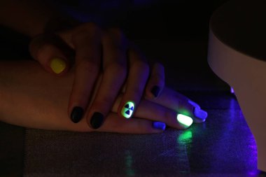 jel gomalak vernik, bir radyoaktif tehlike işareti şeklinde orijinal manikür ultraviyole ışıkla karanlıkta parlıyor.