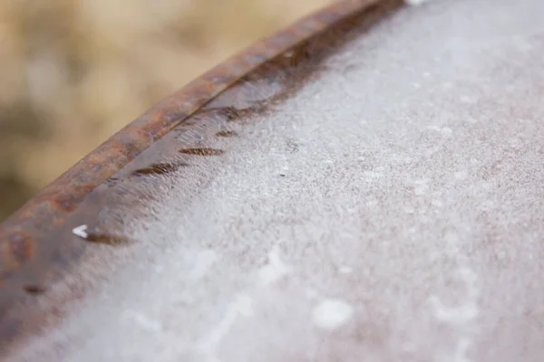 Hielo se congeló en un barril de hierro oxidado. Las burbujas blancas crearon un hermoso diseño natural. hielo de invierno . — Foto de Stock