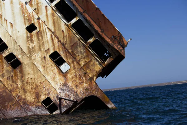 Un barco hundido en el mar, llevando contrabando y volando sobre las piedras. marco oxidado . — Foto de Stock