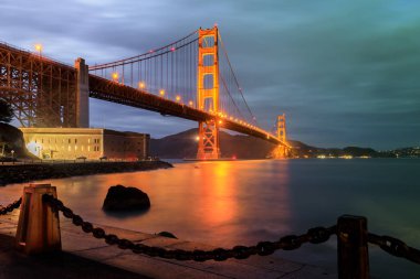 Golden Gate Köprüsü ve zincir bağlantı çit geceleri. Fort Point, San Francisco, Kaliforniya, ABD.