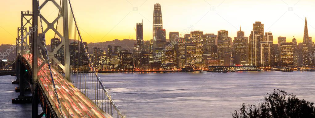 San Francisco Downtown and Bay Bridge in the golden hours. Panoramic view of San Francisco water front from Yerba Buena Island, California, USA.