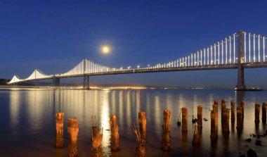 San Francisco-Oakland Körfezi Köprüsü dolunay gece karanlığında yükselen ile. Embarcadero, San Francisco, Kaliforniya, ABD.