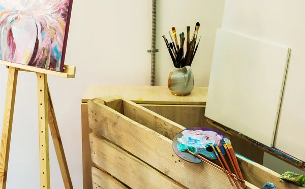 artist\'s workshop. Easel with brushes and tubes of paint
