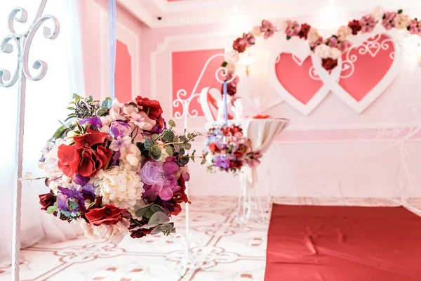 Цветочные украшения в большом зале в день свадьбы на фоне арки — стоковое фото