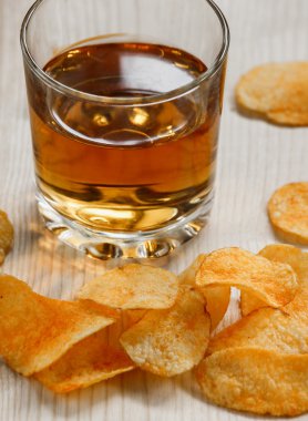 patates cipsi ve bir bardak elma suyu üzerinde ahşap table.potato cips ve bir bardak viski