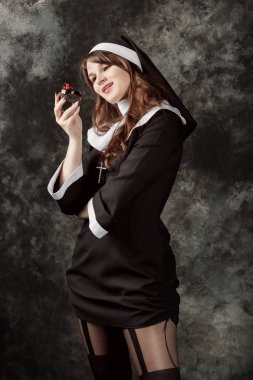 bir çikolatalı kek çilek ile karanlık bir arka plan üzerinde tutan çekici Rahibe