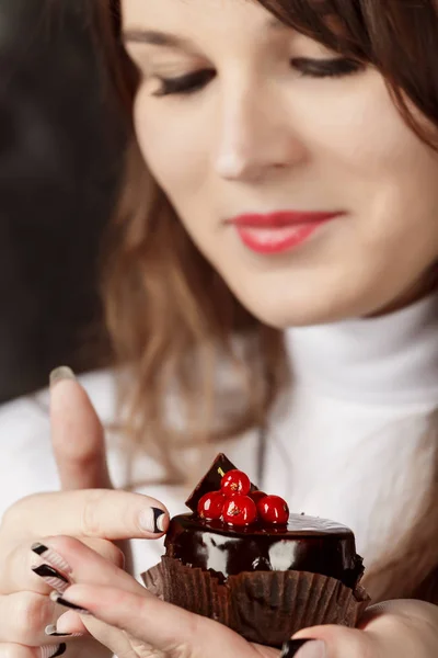 어두운 배경에 딸기와 초콜릿 케이크를 들고 하는 매력적인 수녀 — 스톡 사진