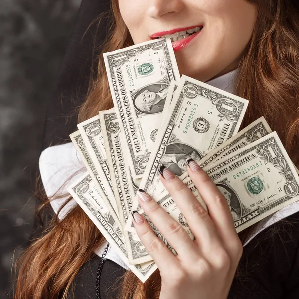 Nahaufnahme einer Frau, die Dollarscheine in der Hand hält und ihm einen Dollar aus den Zähnen zieht — Stockfoto