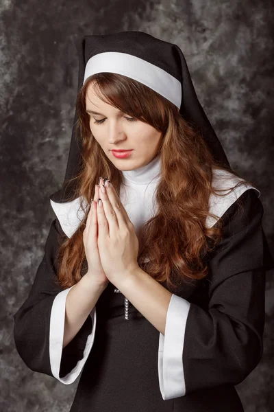 Religieuze nun in religie concept tegen de donkere achtergrond — Stockfoto