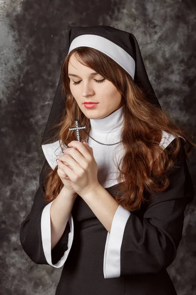 Religieuze nun in religie concept tegen de donkere achtergrond — Stockfoto