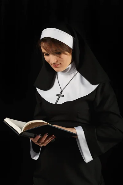 Religieuze nun in religie concept tegen de donkere achtergrond — Stockfoto