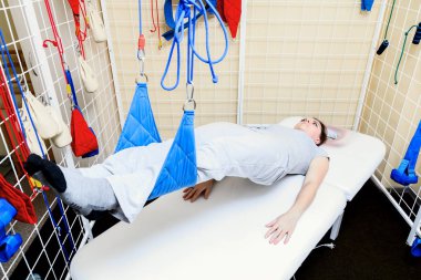 genç kadın hasta bir rehabilitasyon çalışmada fiziksel egzersizleri yapıyor.