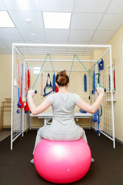 Young woman patient doing physical exercises in a rehabilitation study. — Stock Photo, Image