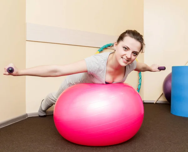 年轻的女病人在健身球上做操的康复 study.young 女子体育锻炼 — 图库照片