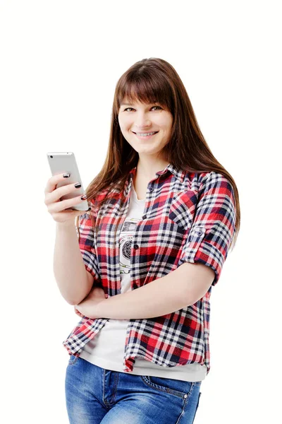 Attractive brunette in jeans and a plaid shirt In Use your mobile phone — Stock Photo, Image