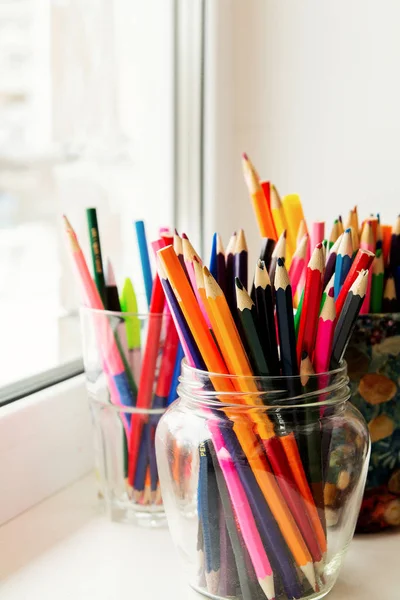 Crayons de couleur dans des pots de verre dans une fenêtre de l'école — Photo
